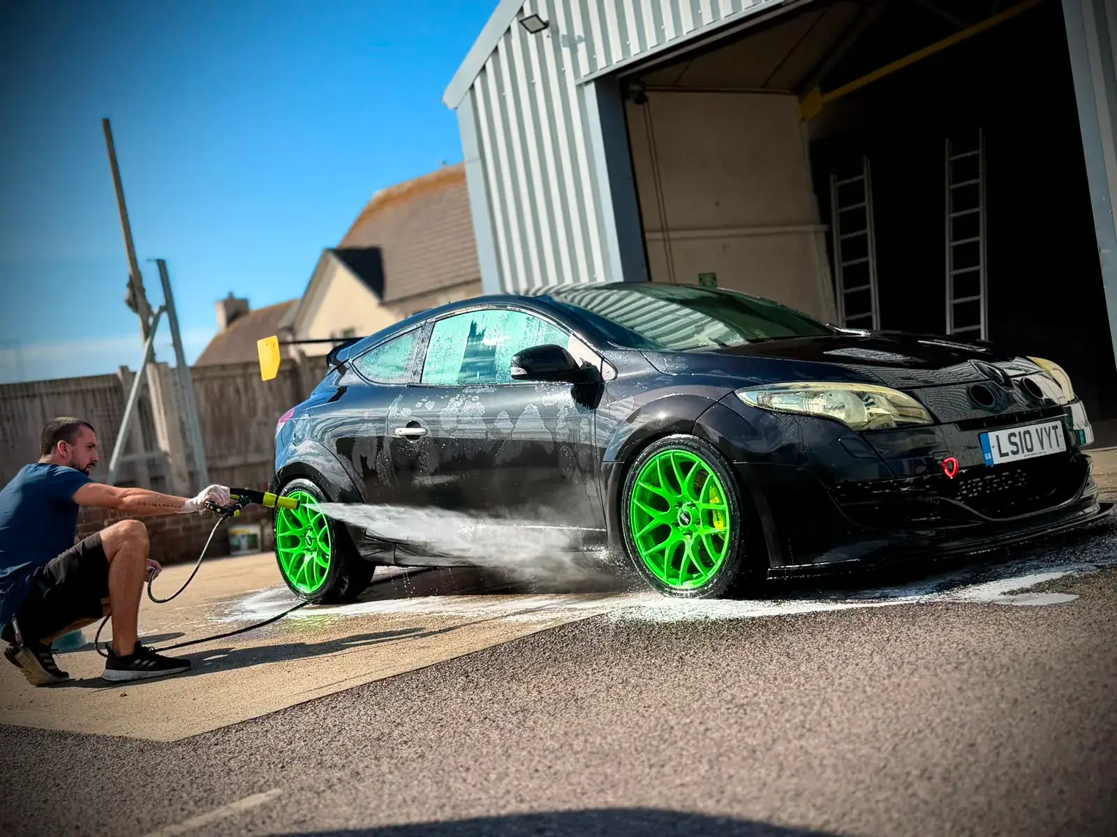 The Megane R.S. arriving at P1 Wraps in plain black with green wheels
