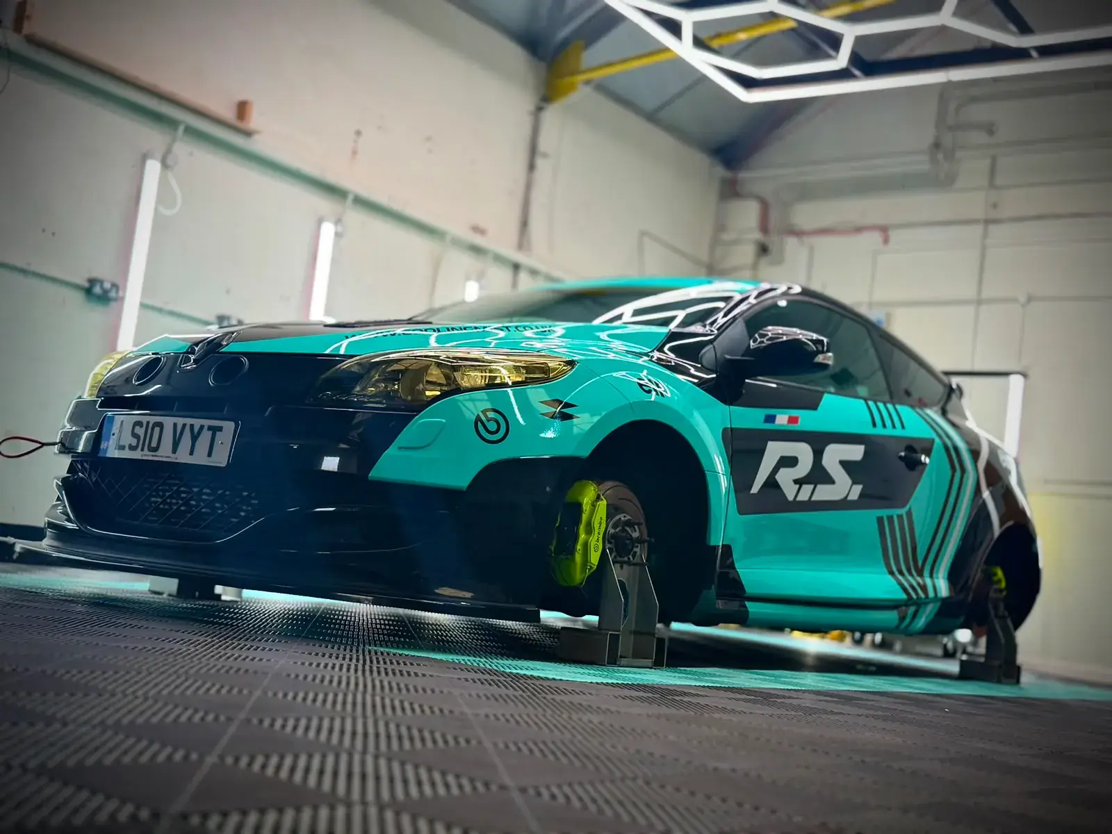 The Megane supported on hub stands with the wheels removed