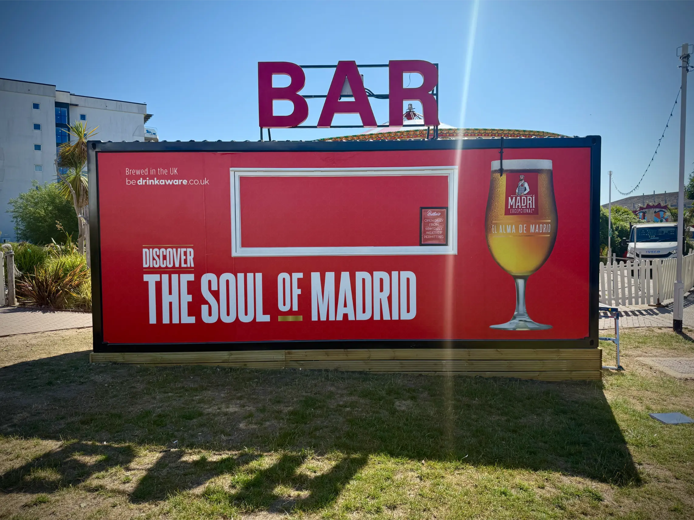 Outdoor bar structure wrapped in Cruzcampo campaign vinyl